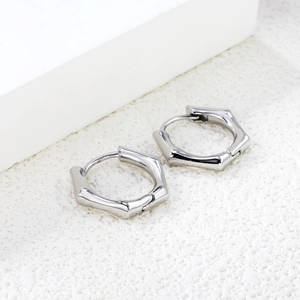 Créoles hexagonales en acier inoxydable argenté poli avec texture bambou sur fond blanc