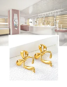 Gros plan sur les boucles d'oreilles nœud papillon en acier inoxydable plaqué or 18k
