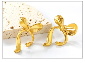 Gros plan de boucles d'oreilles nœud plaquées or 18 carats avec finition satinée mate