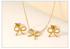 Gros plan sur l'ensemble collier et boucles d'oreilles nœud doré avec texture corde