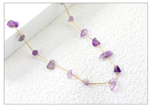 Close-up of natural purple amethyst stones on a dainty gold stainless steel chain