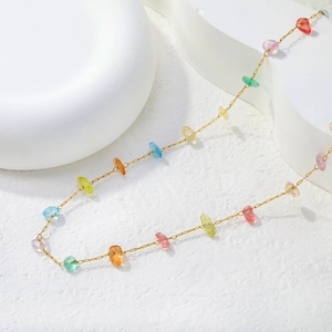 Detail of gold chain necklace featuring colorful translucent irregular gemstone charms