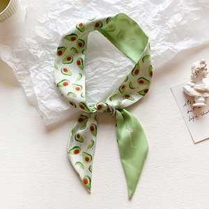 Close-up of green tie-dye silk scarf with realistic avocado print and diagonal cut ends