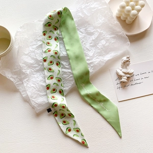 Macro detail of twilly scarf with green avocado print and solid sage green reverse side