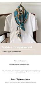 Détail d'un foulard carré effet soie avec des motifs de chaînes dorées sur fond bleu marine