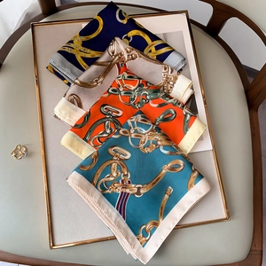 Détails de foulards en satin soyeux avec chaînes dorées et motifs équestres classiques