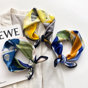 Three elegant silk square scarves with balloon prints on a white blazer background