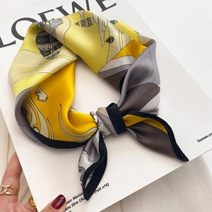Detail of a silk square scarf with yellow and gray hot air balloon print on a magazine