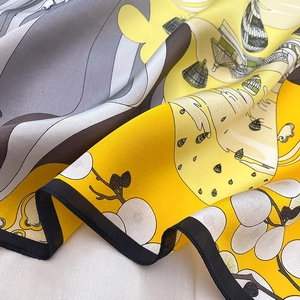 Close-up of printed silk scarf showing intricate architectural patterns and fine stitching