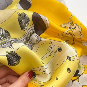 Detail of silk scarf showing yellow oriental pavilion print and satin texture
