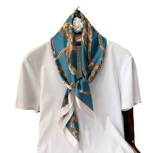 Foulard en soie bleu sarcelle à motifs de chaînes dorées sur un t-shirt blanc uni