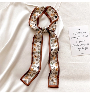Detailed view of the floral print silk scarf tied on a white camisole strap accessory