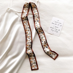Floral print narrow silk scarf styled as a hair ribbon on white satin dress background
