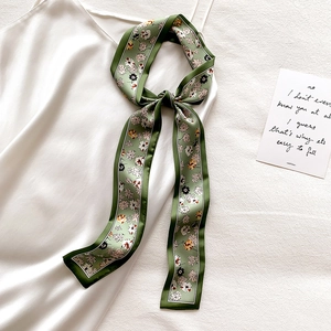 Floral print narrow skinny scarf tied as a bow on a white dress for elegant styling