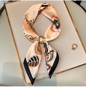 Detail of silk-feel square scarf with abstract leaf print and elegant orange accents