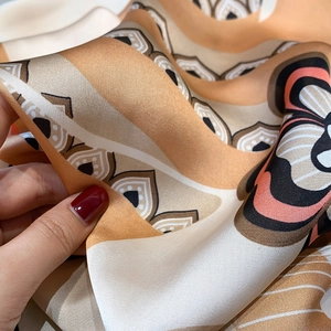 Close-up of silky square scarf showing bohemian floral print and smooth texture