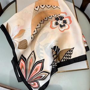 Detailed close-up showing silk texture and vintage floral patterns on a fashion square scarf