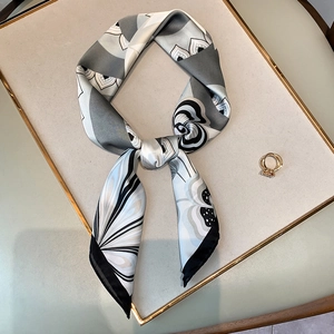Elegant black and white printed silk scarf with geometric floral patterns and gold ring