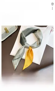 Detail of grey-green silk scarf styled on a white T-shirt with high satin gloss finish