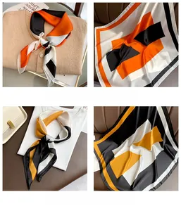 Detailed view of geometric patterned silk scarves with elegant machine-rolled hem finish