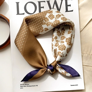 Elegant silk scarf with paisley floral print on magazine, styled as a premium accessory