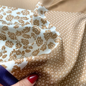 Detail of silk scarf showing floral paisley print and smooth satin texture closeup