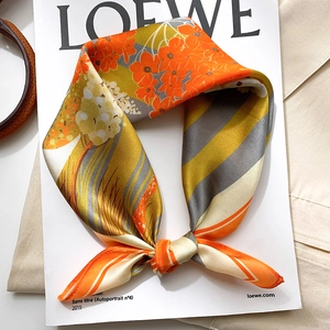Floral and striped silk scarf in orange and grey, styled as an elegant necktie knot