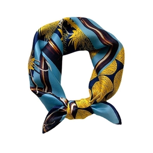 Silk square scarf featuring blue and yellow floral prints in an elegant knotted style