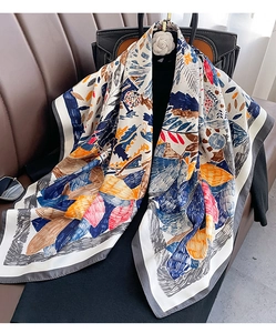 Detailed view of the abstract floral pattern on a silk scarf with rich blue and orange tones