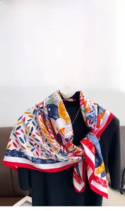 Detailed macro view of retro floral print silk scarf with vibrant red border texture