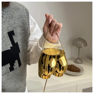 Detailed view of creative gold butt-shaped metallic handbag with fine metal chain handle