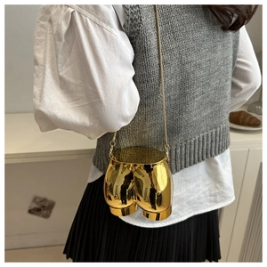 Macro detail of a creative gold mirror-finish hip-shaped crossbody bag with a chain