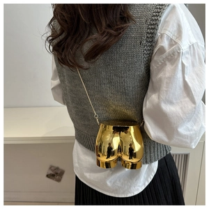 Detail of creative gold butt-shaped mini crossbody bag with a delicate metal chain strap