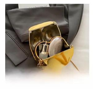 Inside view of gold lip-shaped clutch showing storage for lipstick and powder with chain