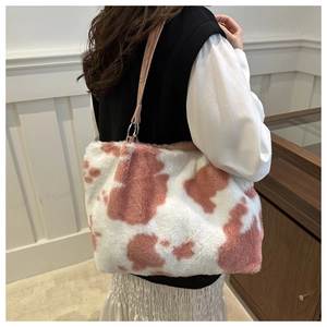 Détail du sac fourre-tout en peluche rose à motif vache avec anneaux métalliques