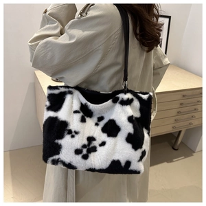 Détail du cabas en peluche à motif vache avec fausse fourrure et bandoulière noire