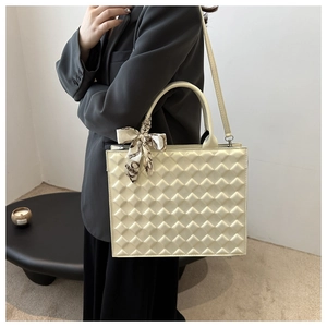 Ivory quilted crossbody bag with silk scarf detail styled on an elegant model