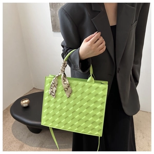 Lime green quilted handbag with decorative silk scarf and adjustable shoulder strap
