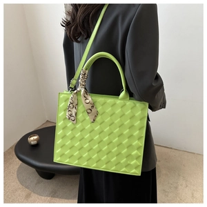 Fluorescent green crossbody bag with diamond quilted texture and silk scarf handle detail