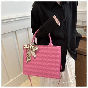 Close-up of pink quilted crossbody bag with silk scarf detail and textured finish