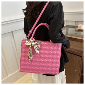 Detail of rose pink quilted tote bag featuring a decorative silk scarf on the handle