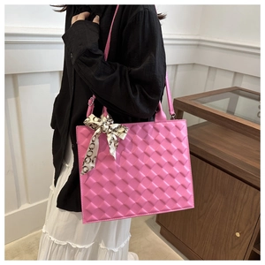 Close-up of pink quilted tote bag featuring elegant silk scarf handle and golden details