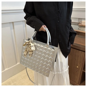 Detailed macro view of silver quilted tote bag with diamond texture and silk scarf handle