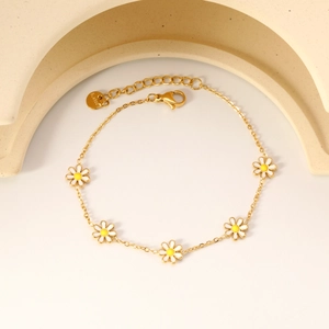 Gold stainless steel daisy chain bracelet featuring white enamel flowers and lobster clasp