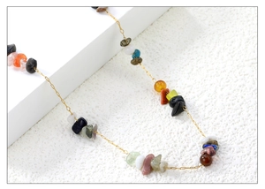 Macro-opname van Franse vintage gouden ketting met kleurrijke onregelmatige natuursteen