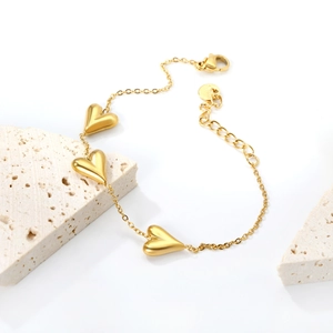 Polished 18K gold plated stainless steel bracelet with three 3D heart pendants on stone