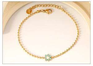 Detail of gold beaded bracelet with light blue enamel daisy charm and S.steel hallmark