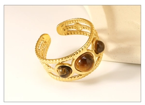 Detailed view of gold rope textured cuff ring featuring three round tiger eye stones
