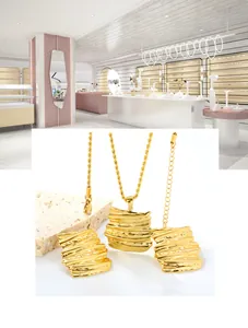 Detailed view of gold wavy rectangular pendant necklaces and matching earrings set
