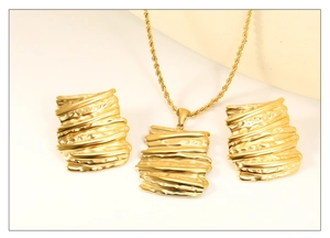 Detailed macro view of gold jewelry set featuring wrinkled metal texture and twisted chain